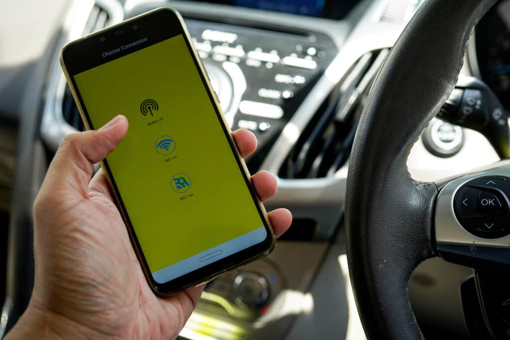 Une personne avec un téléphone se connectant à sa voiture