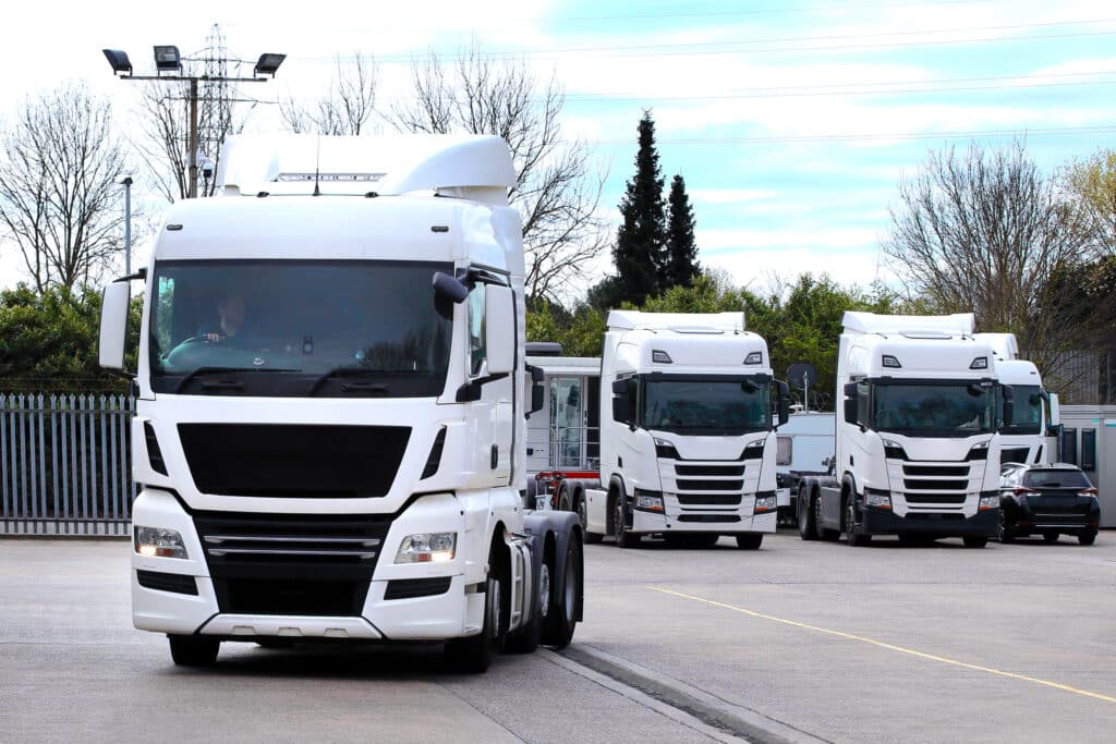 camions d'une flotte qui sortent d'un parking